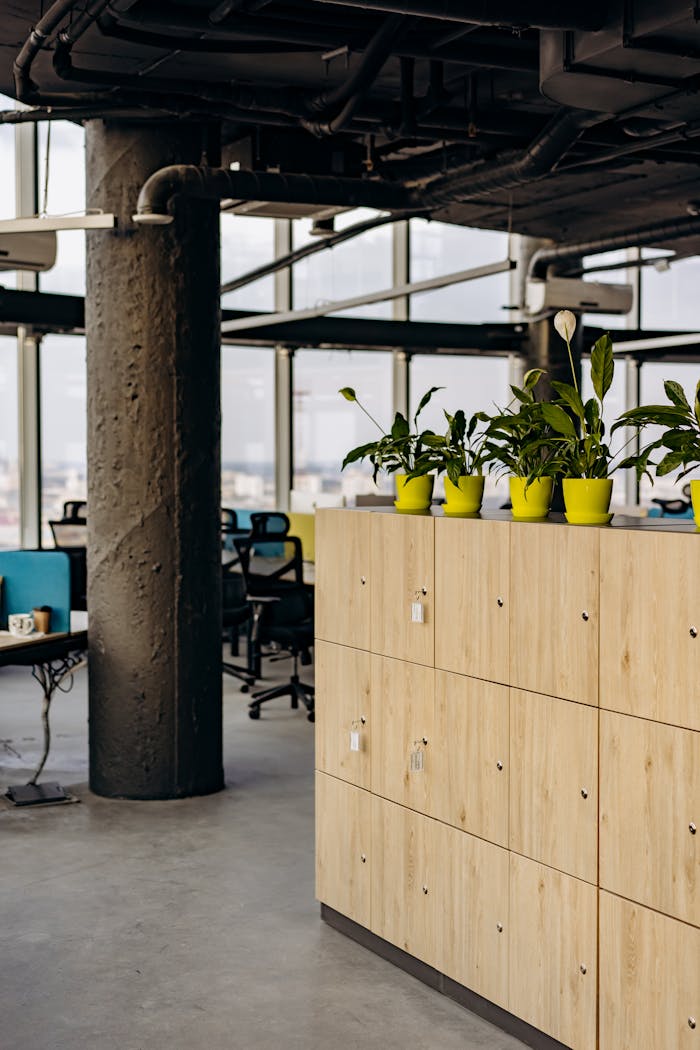 Contemporary open office design featuring wooden lockers and vibrant indoor plants.